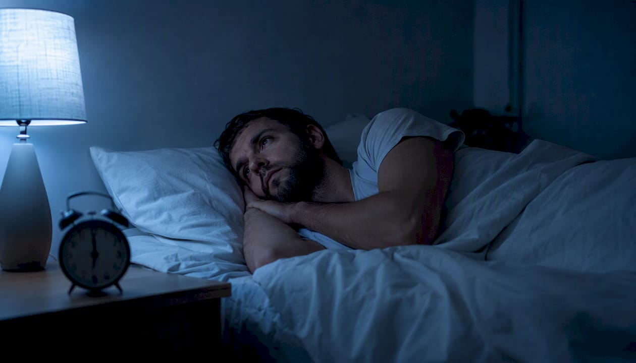 Person lying awake in bed at night