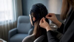 Hands adjusting EEG cap connection during neurofeedback