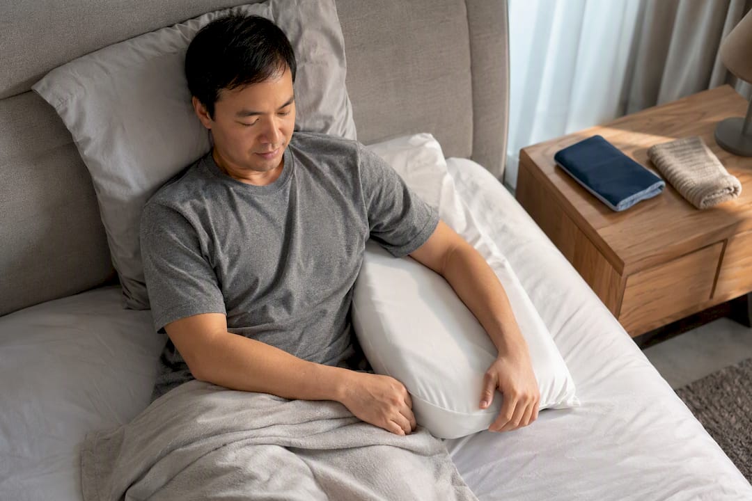 Arm supported by pillow during sleep positioning